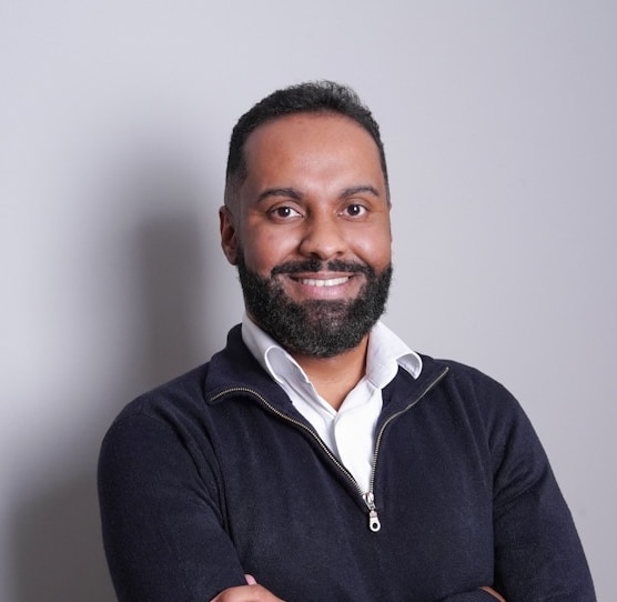 Headshot of a professional-looking man with a beard wearing business casual clothing.
